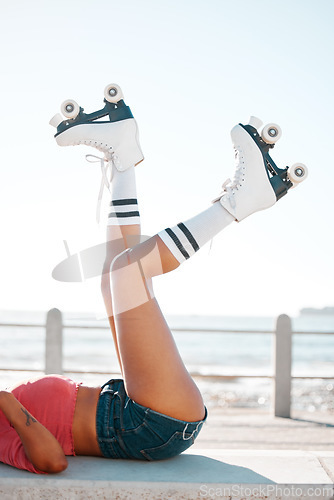 Image of Fun, roller skates and beach vacation in summer with woman enjoying hobby, relax and freedom while skating. Legs and shoes of a female skater being fit and active while at sea for leisure and travel