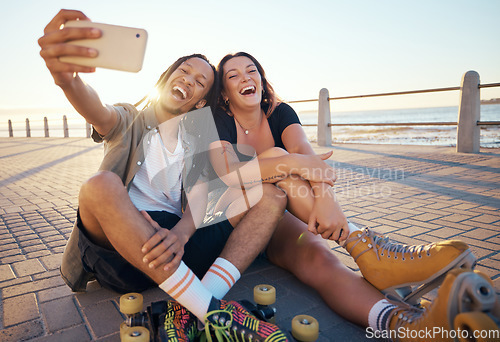 Image of Selfie of young skater friends with phone smile and laugh at the beach. Cool cheerful man and woman smiling and having fun on the weekend. Happy couple with rollerskate having fun together outside