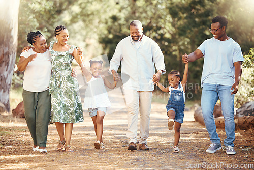 Image of Black family, hiking or bond with children, parents or grandparents walking in remote nature forest and countryside. Happy mother, father or senior holding hands with girls and skipping in tree park