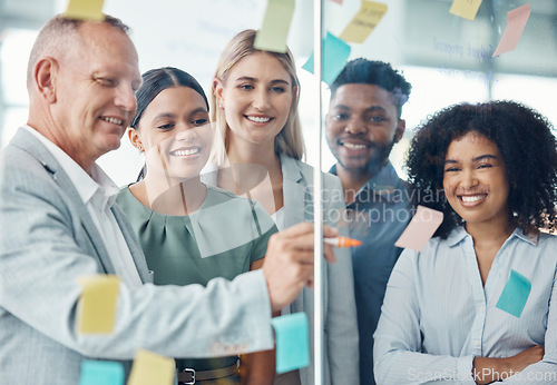 Image of Team, strategy and business people writing on sticky notes in a meeting about the vision, mission and goals of the company. Teamwork, smile and happy group of employees brainstorming in modern office