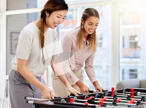 Image of Business women playing table soccer, laughing and having office fun at their corporate job. Diverse female colleagues bonding while competing in a friendly foosball game during a break together
