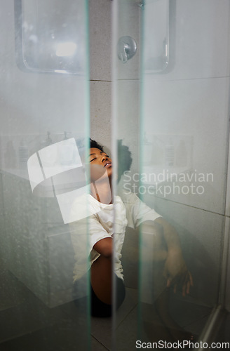 Image of Mental health, anxiety and depression by sad woman sitting on floor the of a shower, stress and afraid. Young female suffering from a panic attack, fear or phobia while looking exhausted and anxious