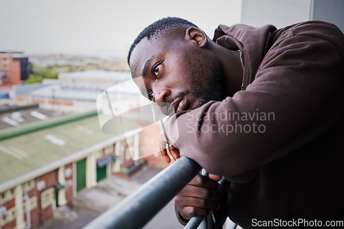 Image of Sad, tired and depressed man on balcony of apartment, thinking of mental health in house and anxiety from problem at home. Face of African person with depression and burnout thinking of idea