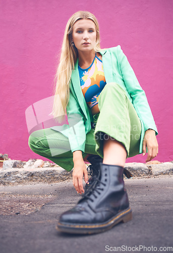 Image of Fashion content creator and social media influencer in neon clothes and cool modern pose outdoors on the road. Photography, green and portrait of a young woman on the city street against a pink wall