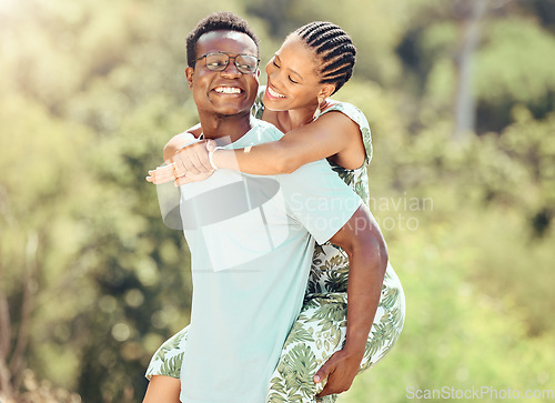 Image of Love, date and outdoor couple in park or romantic nature outing for healthy, green lifestyle with trees, bokeh and lens flare. Happy, wellness black people and caring man giving woman piggyback ride