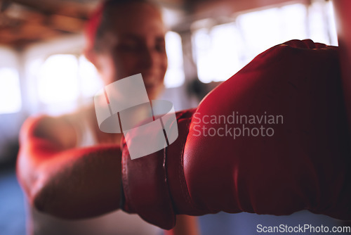 Image of Boxing, fitness and sport with strong woman, boxing gloves to hit, punch and fight during training at a gym. Fit and athletic boxer female doing a workout during self defense exercise class