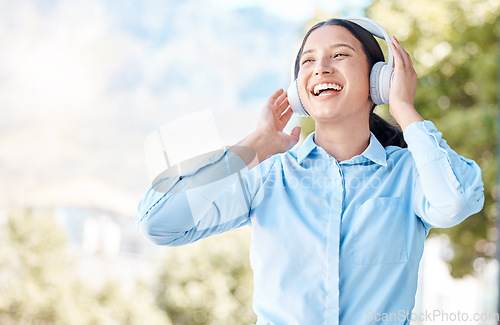 Image of Woman with headphones happy listening to music on mp3 audio streaming song app singing to popular singer artist. Girl or young person smile, happiness and dancing to good internet joy and fun radio