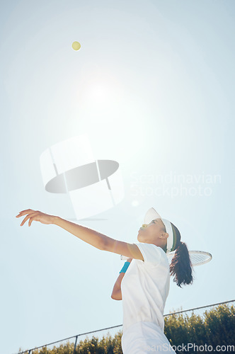 Image of Tennis court, outdoor girl and ball in sky after professional hit with sports racket in match. Woman champion, competition and talented and fit athlete person with expert game play technique.