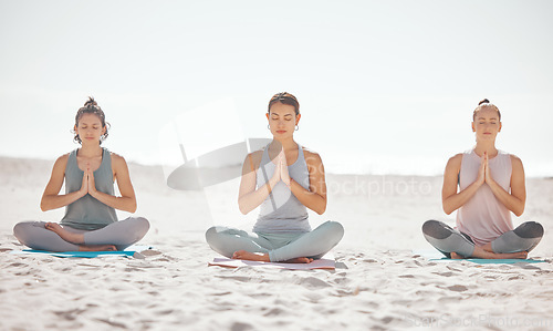 Image of Beach meditation, women or zen friends in mental health wellness exercise, pilates training or mind reiki energy yoga. Relax, namaste prayer hands or people in peace breathing support workout on sand