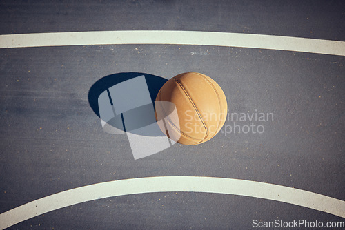 Image of Basketball, empty game court and sports ball ready for sport exercise and health training. Top view of orange workout fitness tool for fun team sport with a light shining casting a shadow on a floor