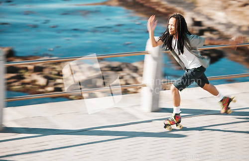 Image of Freedom, energy and roller skating with black man training and exercise along a beach outdoors. Active African American enjoying intense speed practice of fitness hobby, cardio and balance workout
