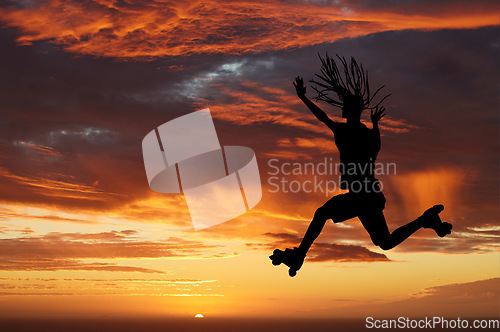 Image of Sunset sky, silhouette and roller skates woman jumping against an orange horizon while enjoying freedom, travel and fun while skating. Energy, scenery and beauty of nature while out on an adventure