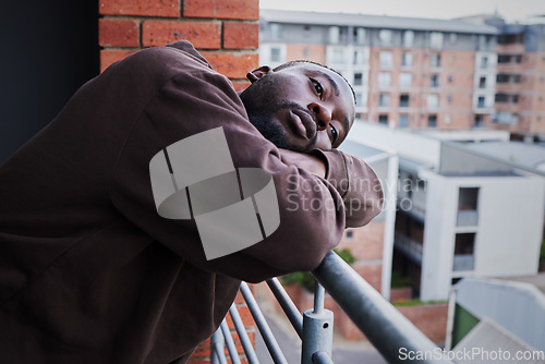 Image of Depression in covid pandemic with a sad man suffering from mental illness, lonely while outside on a balcony. Unhappy male feeling hopeless and annoyed, frustrated with compliance and corona rules