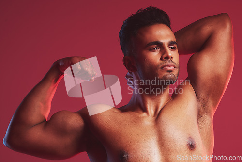 Image of Fitness, health and nude man with muscle on a red studio background. Exercise, training and sports with a proud, strong and muscular weightlifting bodybuilder flexing his bicep after strength workout