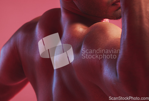 Image of Sexy man, strong back and muscle bodybuilder in nude, fitness and skin against colorful studio background. Naked, healthy and powerful guy closeup with shoulder strength, muscular and flexing arms