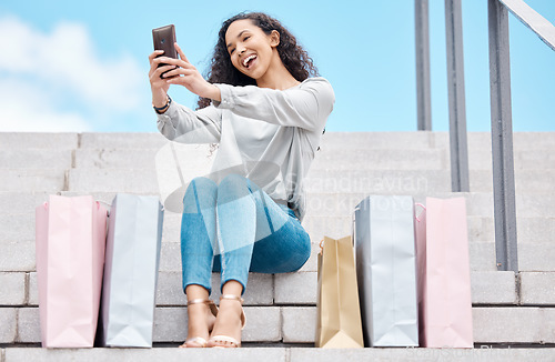 Image of Selfie, shopping and female influencer and blogger sitting outside with bags after a spending spree while on city stairs. Happy, consumer or customer live streaming fashion sale and promotion offer