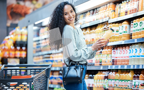 Image of Portrait of a woman with juice while shopping in a grocery store with a retail product sale. Happy customer with a wellness, health and diet lifestyle buying healthy groceries at a supermarket.