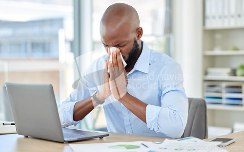 Image of Black man, covid and flu in office by laptop, desk or research documents in company. Sick businessman or worker blowing nose with tissue, suffering from healthcare virus and medical wellness crisis