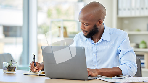 Image of Planning notebook, laptop and businessman working online idea, brainstorming or project management at an office desk. Productive corporate black man writing website ecommerce or tech finance strategy