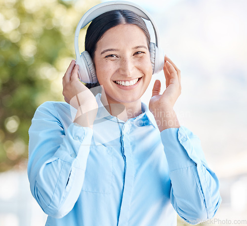 Image of Music, listening and headphones with a woman using bluetooth to listen to a podcast, radio or audio outside with a smile. Portrait of a happy young female streaming with a subscription service