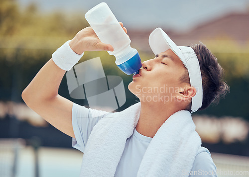 Image of Asian man drinking water, fitness and relax after a training session, workout or exercise. Athlete, health and sports male resting with refreshing liquid after playing a sport, cardio or running.