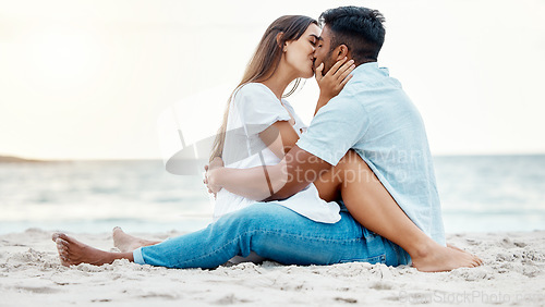 Image of Kiss, beach and love of couple on a date for anniversary, valentines day or romance summer holiday with clear sky, ocean waves and sand. Romantic, intimate and marriage honeymoon or engagement people