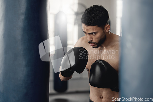 Image of Boxing man, punching bag and strong power, focus mma and fighter training challenge in gym club, exercise and combat sports. Fitness champion, healthy warrior athlete and pro boxer gloves hit impact