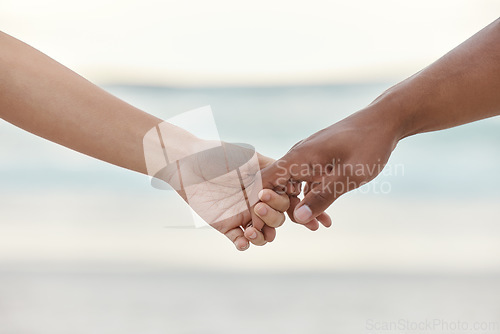 Image of Touch, love and support with interracial couple holding hands in a committed, loving and close relationship. Closeup hands of man and woman enjoying beach travel, sea vacation or holiday and romance