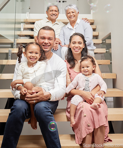 Image of Portrait of a happy family posing for a picture on stairs in a house, smiling and relaxing together. Happy children bonding and enjoying time with their parents on a visit to their grandparents home