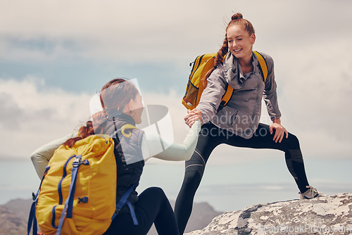 Image of Help hands, friends or women hiking up a mountain, hill or in nature with a smile. Travel, adventure and trekking females on an outdoor, countryside or rock climbing recreation exercise activity.