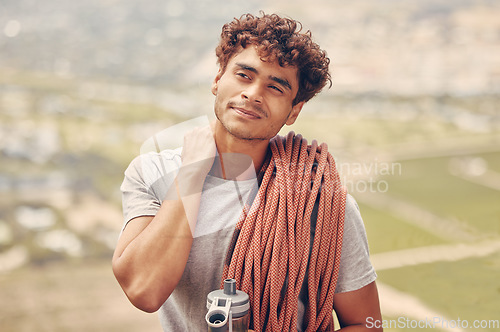 Image of Man on a mountain rock climb or hike trip with a rope and water bottle outdoors in nature. Young, healthy and active guy on a fitness adventure with neck pain to explore with safety equipment.
