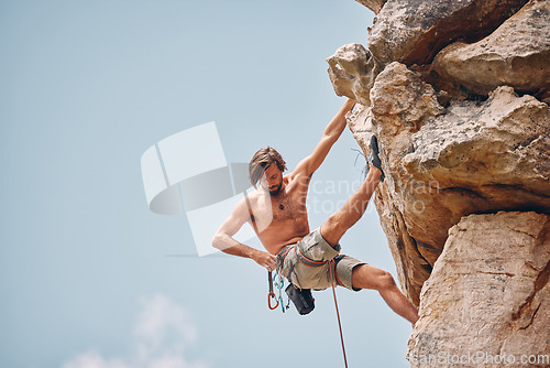 Image of Mountain or rock climbing, cliff hanging and adrenaline junkie out on adventure and checking his safety equipment, hook and rope. Fearless man doing fitness, exercise and workout during extreme sport