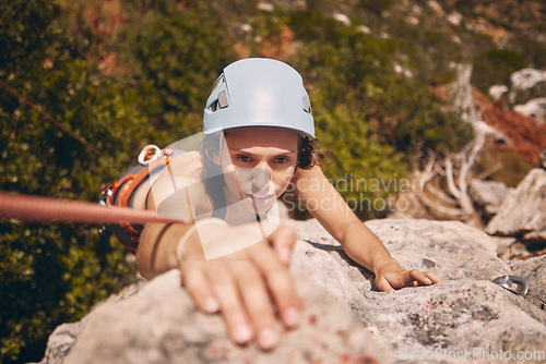 Image of Sports, exercise and mountain climbing with a woman climber scaling or abseiling a cliff. Fitness, workout and training with a young female on a climb in the forest or woods in nature from above