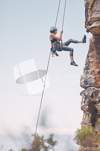 Image of Woman climbing mountain with rope, outdoor nature activity and fitness exercise. Cliff rock climb, mountaineering adventure and action danger risk. Safety gear, peaceful earth and freedom motivation