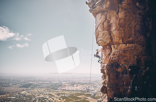 Image of Mountain, rock climbing and sport with a sports woman and climber abseiling on a mountainside outdoor in nature. Fitness, exercise and training with a female athele using a rop to climb a cliff