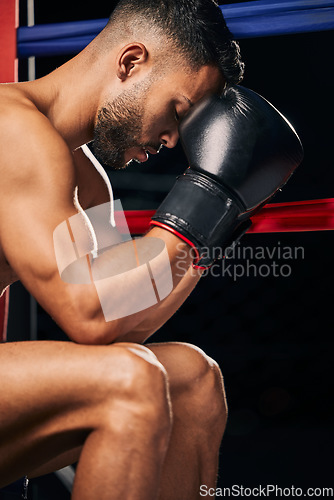 Image of Boxing gloves, boxer sports man in fight match or prepare for tournament Fitness, training and strong or powerful young prizefighter sitting in a ring thinking of technique, motivation or challenge