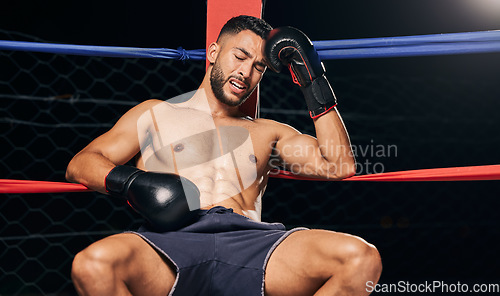 Image of Sports, boxing ring and tired frustrated boxer with head pain, injury or fatigue from exhibition competition. Defeat or failure in fight challenge, workout or training burnout from fitness exercise