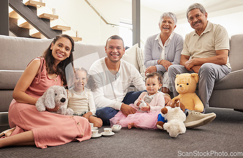 Image of Portrait of a happy family having a tea party in a living room together, smiling and relaxing on a floor. Cheerful grandparents enjoying the weekend with their grandkid, being playful and having fun