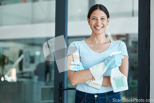 Image of Cleaning service, portrait and cleaner in an office with spray bottle of disinfectant, bleach or detergent. Happy, smile and young female worker with gloves and soap liquid done washing glass windows