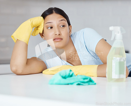 Image of Cleaning, covid and hygiene with a bored woman cleaner looking at a spray bottle or sanitizer with a negative expression. Chores, clean and sanitizing with a young female unhappy about housework