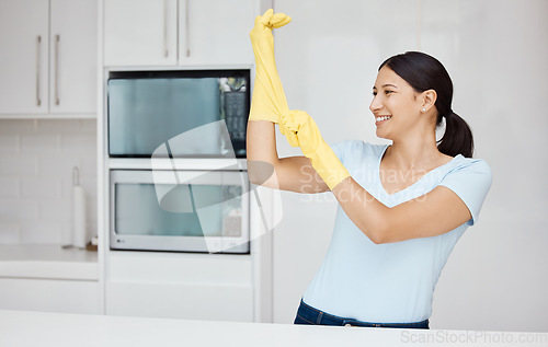 Image of Cleaning, safety and sanitizing with a woman cleaner in rubber gloves ready to do chores and house work. Hygiene, clean and wash with an attractive young female washing her home kitchen with a smile