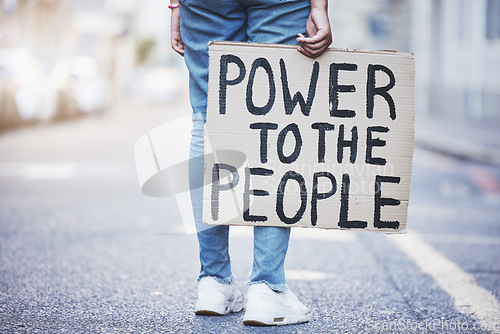 Image of Power to the people cardboard protest poster in a city street for politics, government or human rights. Voice opinion board for freedom, equality or sign for society, racism and poverty background