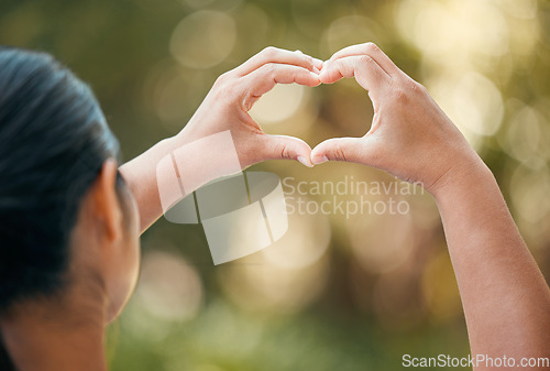 Image of Woman use hands, make heart or love sign outside with bokeh in nature background. Lady with fingers together, show icon or expression of romance against outdoor backdrop with blurred natural light