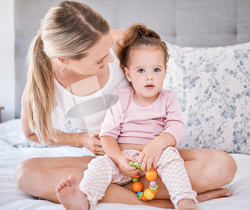 Image of Portrait of girl with mother in bedroom in home, bonding and playing while holding toy. Love, family and caring happy woman with little kid, child or toddler spending free time together in the house