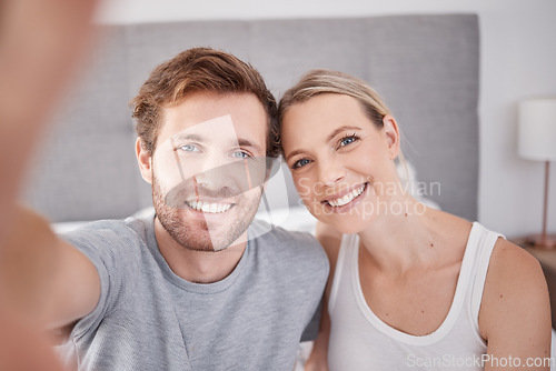 Image of A selfie in bedroom of man and woman as couple. Portrait of young, happy and smiling people taking a picture together in the morning and wearing pajamas. Taking a photo with smile, bonding and love