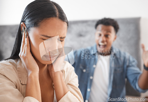 Image of Woman scared, noise and abuse from angry man in the living room at home. Fear, bullying and sad wife cover ears as husband shout, scream or yelling at home with marriage conflict, drama or fight