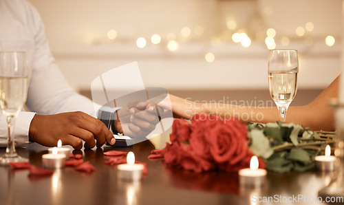 Image of Love, engagement and couple holding hands with wedding ring at restaurant table for proposal, date and celebration. Romance, champagne and happiness with diamond jewellery for marriage