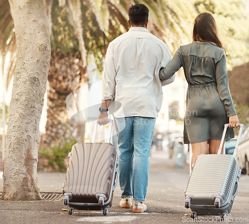 Image of Couple, walking and travel with luggage on vacation for honeymoon in city street abroad. Married man and woman on summer international holiday with bags while walk on a road to accommodation