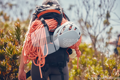 Image of Sports, mountain and climbing with a person hiking and carrying equipment, rope and a helmet outdoor in nature. Adventure, sport and fitness with an adult on a climb, journey or hike in the forest