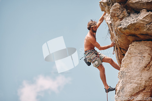 Image of Man mountain or rock climbing while cliff hanging and adrenaline athlete on adventure and check safety equipment, hook and rope. Fearless man doing fitness, exercise and workout during extreme sport